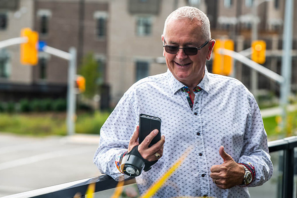 Fostering-independence-for-people-experiencing-hand-tremors image of elderly man looking at his phone