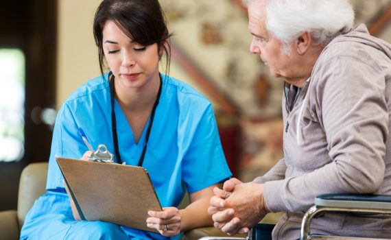 Nurse reveiws patient information with senior man