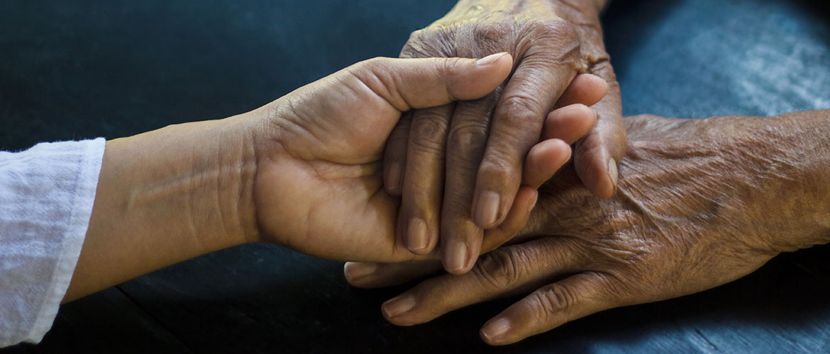 An older woman's hands are held.