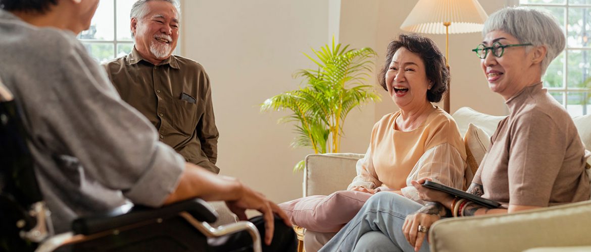 A group of older adults are gathered together laughing.