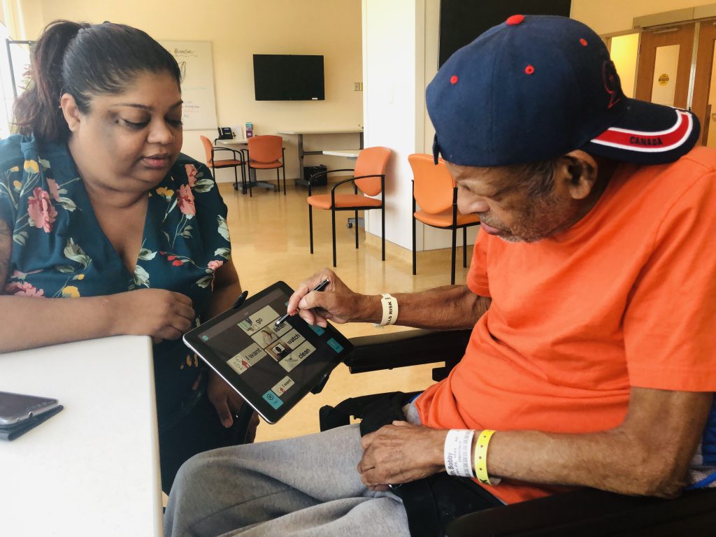 Older male adult uses the Linggo app with a family member