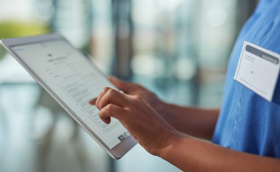 Clinician uses a digital tablet in a hospital
